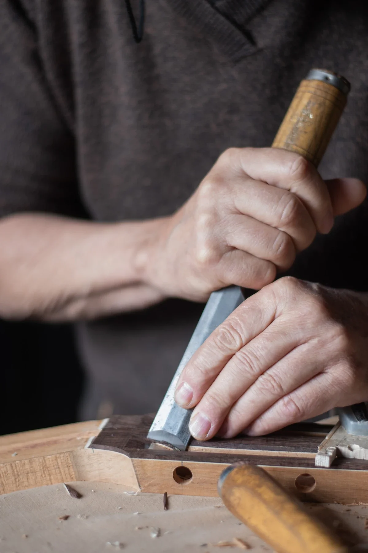 Artisan menuisier travaillant au ciseau sur bois, reportage Entreprise à Saint Genest de Bauzon en Ardèche.