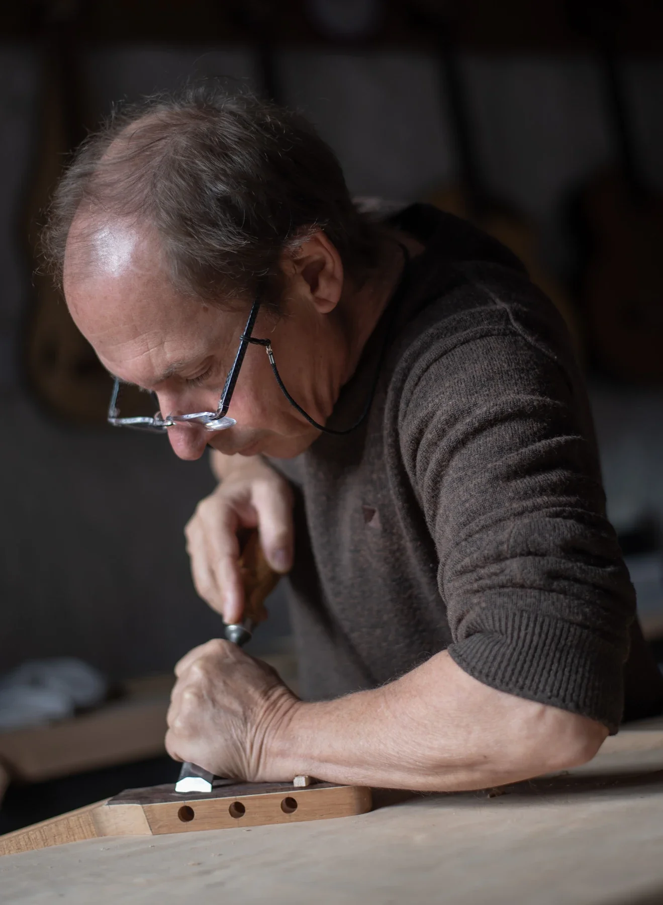 Artisan luthier concentré au travail dans son atelier, Entreprise à Saint Genest de Bauzon en Ardèche.