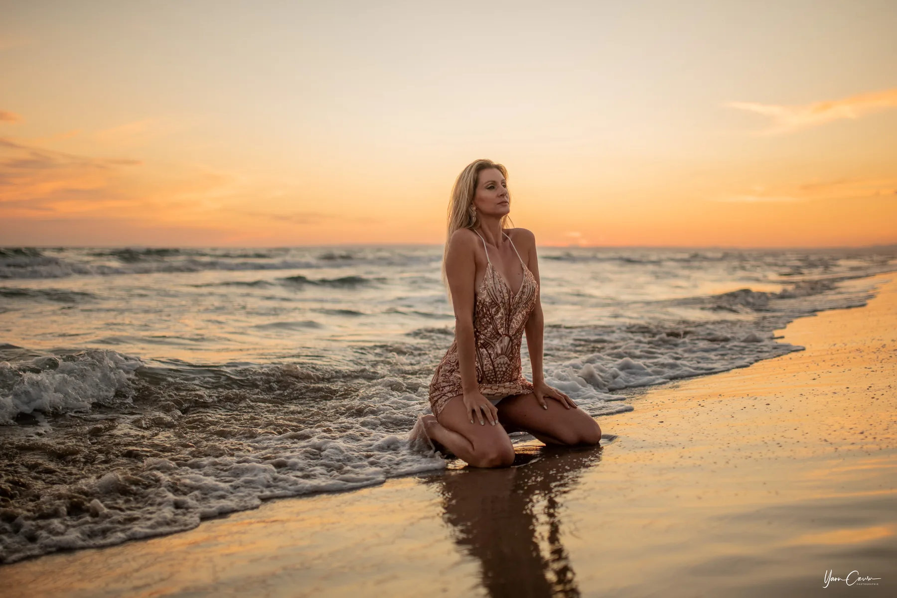 Femme en robe dentelle agenouillée sur plage au coucher soleil, séance plage Camargue