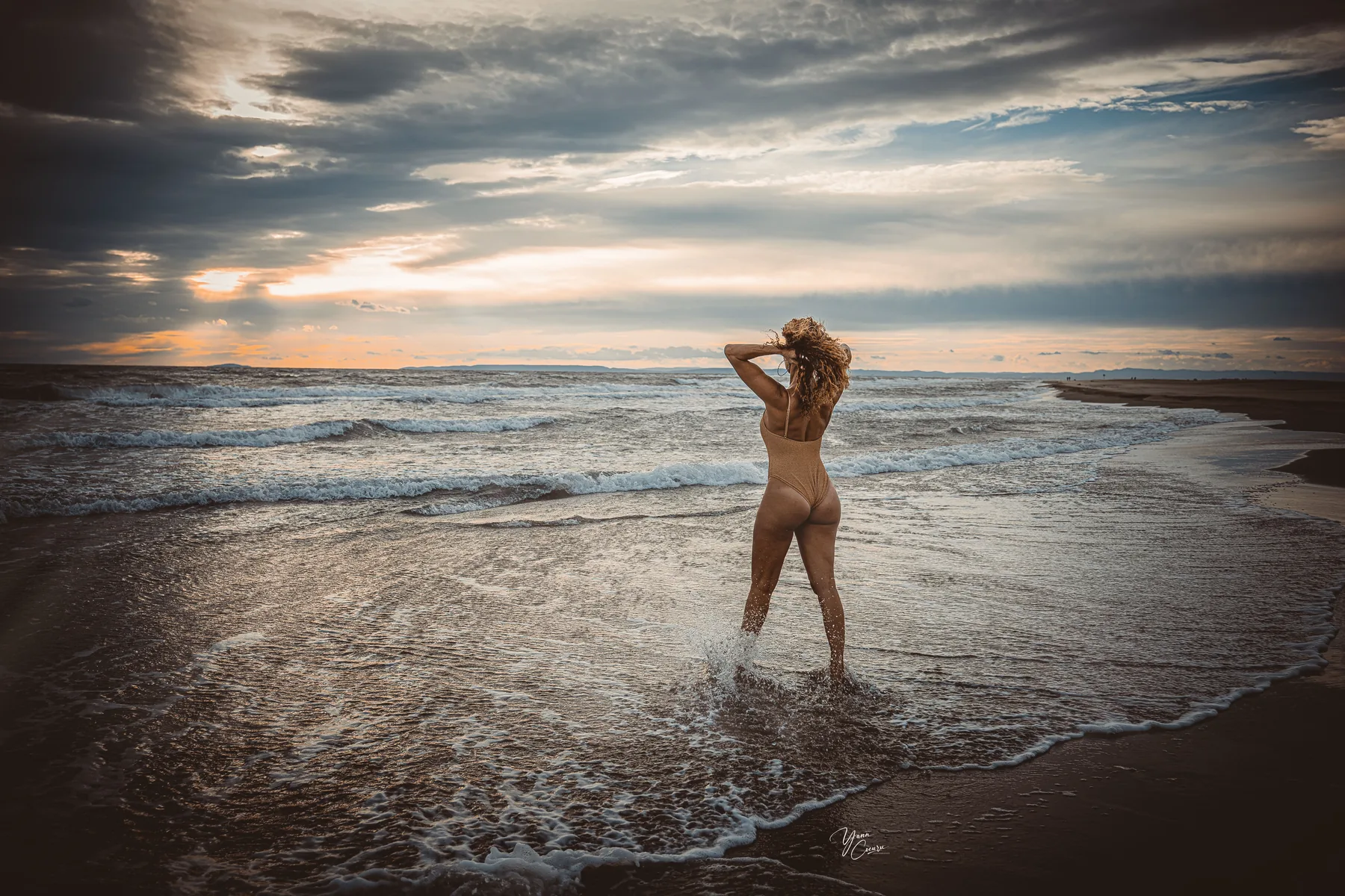 Femme en séance plage Camargue au coucher de soleil, vagues et ciel dramatique